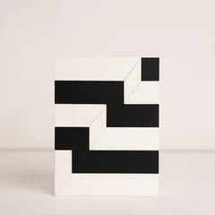 Top-down view of black and white striped birthday gift box in acrylic