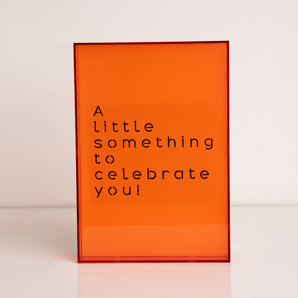 Front view of oversized clear acrylic gift box labeled “A Little Something