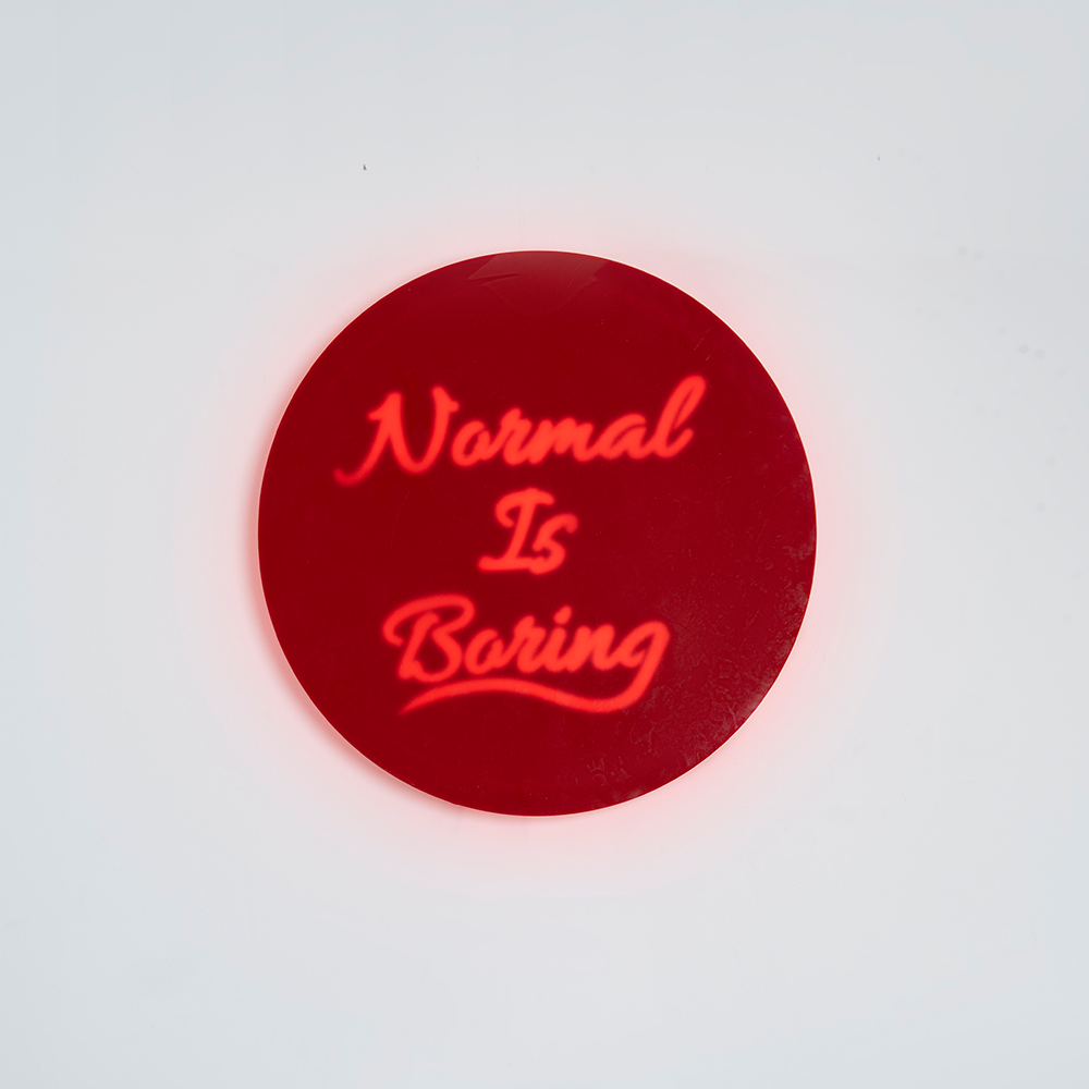 Front shot of wall hanging displaying “Normal Is Boring” text clearly