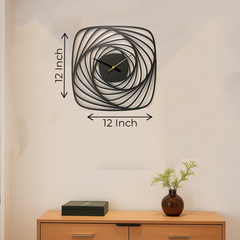 Decorative wall clock with dimensions on a plain wall above a wooden cabinet.